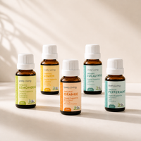 Set of Lively Living essential oil bottles on a neutral background