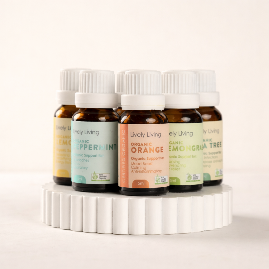 Set of Lively Living essential oil bottles on a white stand with a light background