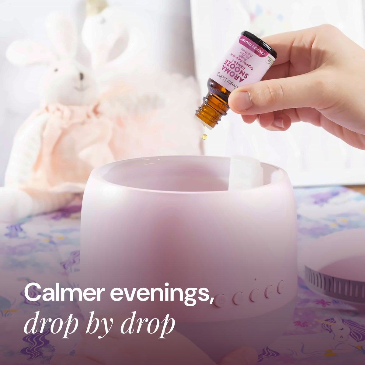 Hand adding drops from a Lively Living oil bottle to a white diffuser in a child's room with a soft toy, with the text Calmer evenings, drop by drop