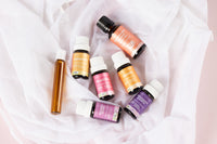 Lively Living essential oils, "womens blend, pregnancy and birth, cocnut body oil, harmony and roller" are sitting on a sheer material. 