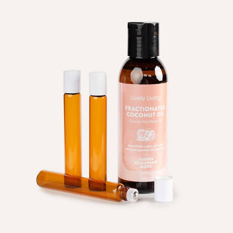 Bottle of Lively Living Fractionated Coconut Oil with two amber glass roller bottles on a light gray background