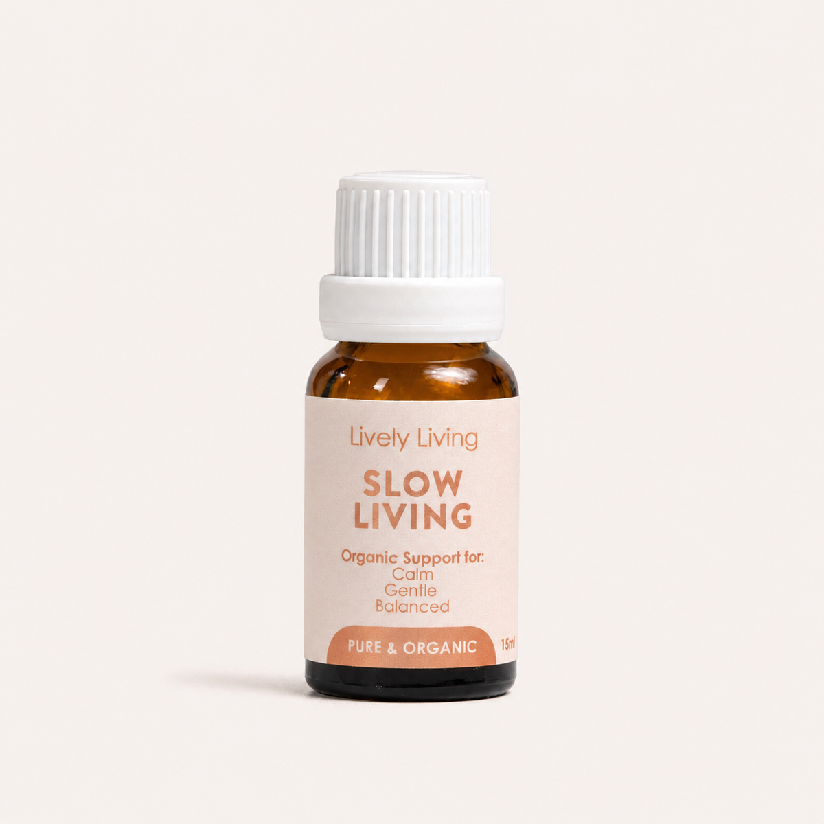 A small amber glass bottle with a white ribbed cap and a pale blush label reading 'Lively Living SLOW LIVING' on a clean off-white background.