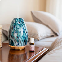 Decorative diffuser and bottle on a wooden surface with a blurred background