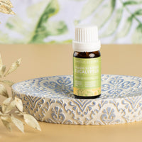 Lemon Scented Eucalyptus essential oil on a patterned ceramic dish with dried foliage