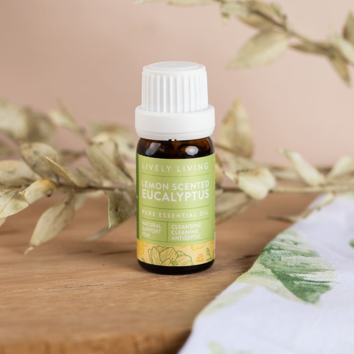Lemon Scented Eucalyptus essential oil on a timber board with dried leaves