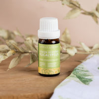 Lemon Scented Eucalyptus essential oil on a timber board with dried leaves