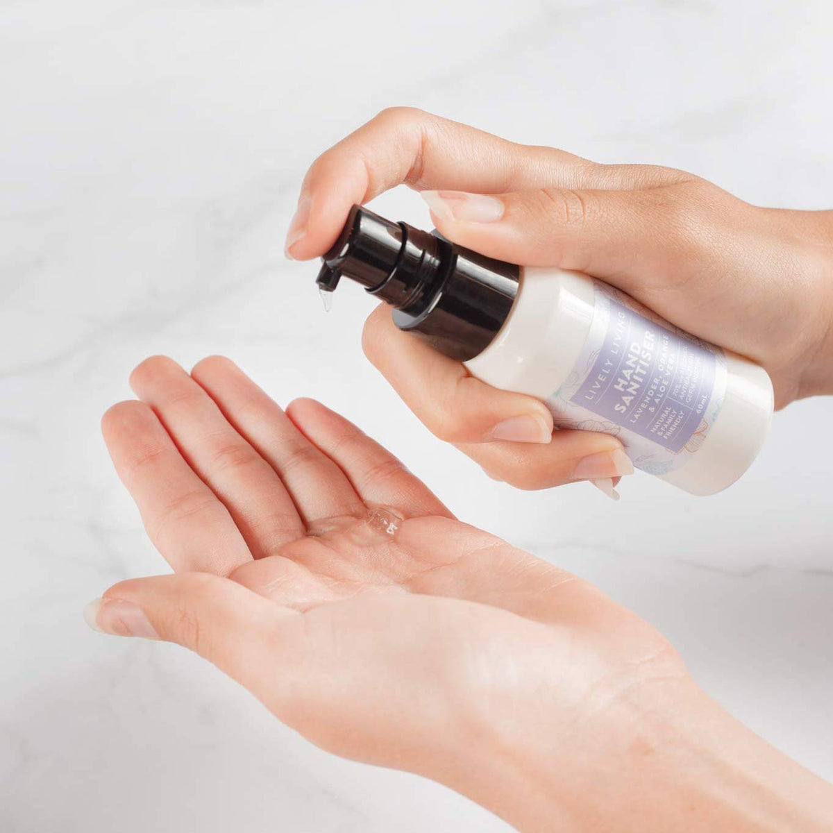 Hands using the Lively Living Hand Sanitiser pump bottle