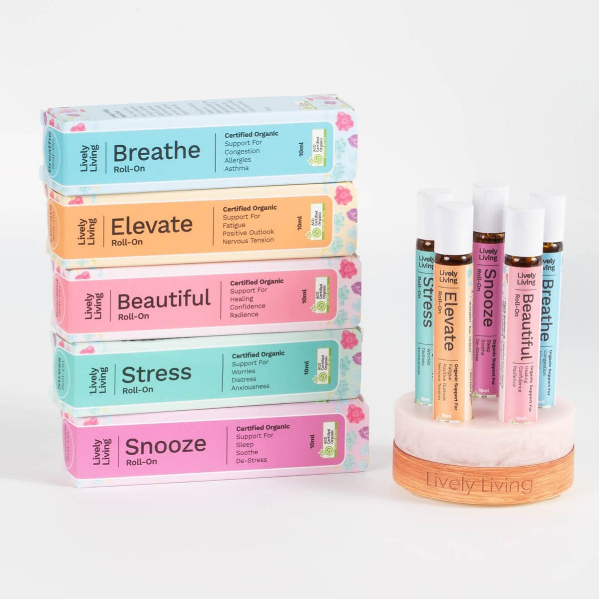 Five boxed roll-ons stacked beside five roll-ons in a marble and timber stand